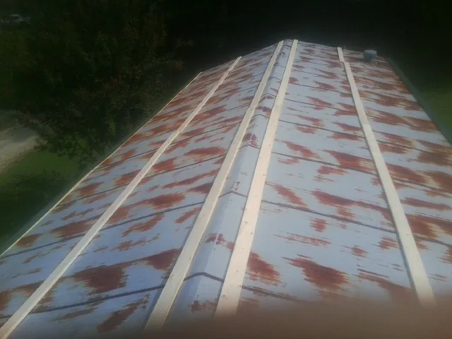 Rusted metal roof panels with new wood purlins before replacement — Storm Damage Roof Repair in Constableville by Roofing Brothers