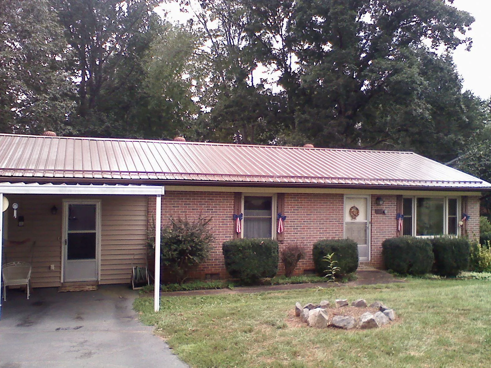 Bronze metal roof and carport on a brick ranch home — Roof Repair work by our crew in Constableville